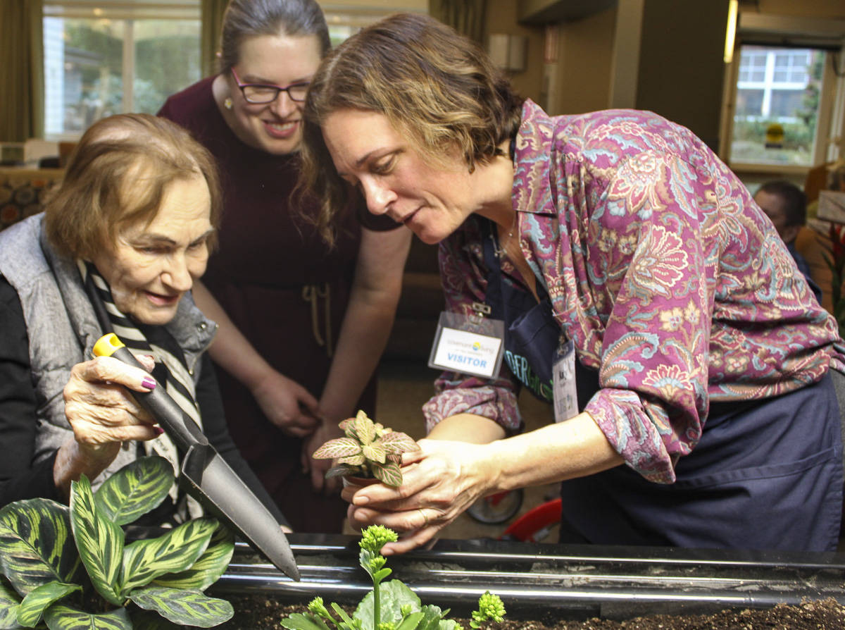 Courtesy photo                                Eldergrow program administrator Katy Dittmer works with Covenant Living at the Shores resident Althea Esterley at the community’s new indoor mobile sensory garden during at Jan. 17 kickoff event.