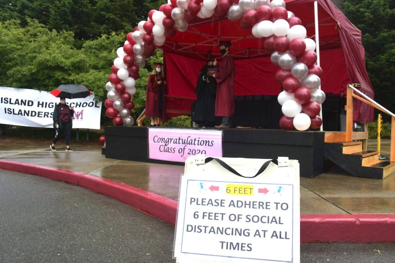 A student receiving a diploma during the drive-thru event from Mercer Island High School Principal Vicki Puckett. Photo by Joe Chen