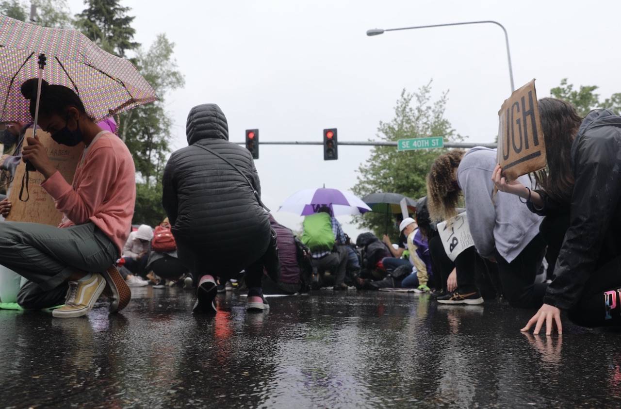 Protestors kneeling in silence at the intersection of Island Crest Way and Southeast 40th Street. The gesture lasted eight minutes and 46 seconds — the amount of time white Minneapolis Police Officer Derek Chauvin knelt on George Floyd’s neck. Staff photo/Blake Peterson