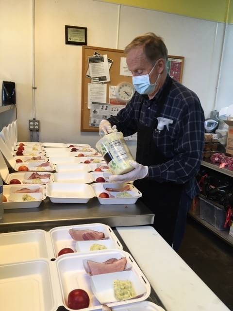 A Mercer Island Rotary Club member prepares box dinners for the homeless at Seattle Operation Nightwatch on Aug. 22. Five local Rotarians prepared 70 dinners, which included ham, potato salad, fruit, cheese and cookies during the club’s near monthly volunteer project. Photo courtesy of the Mercer Island Rotary Club