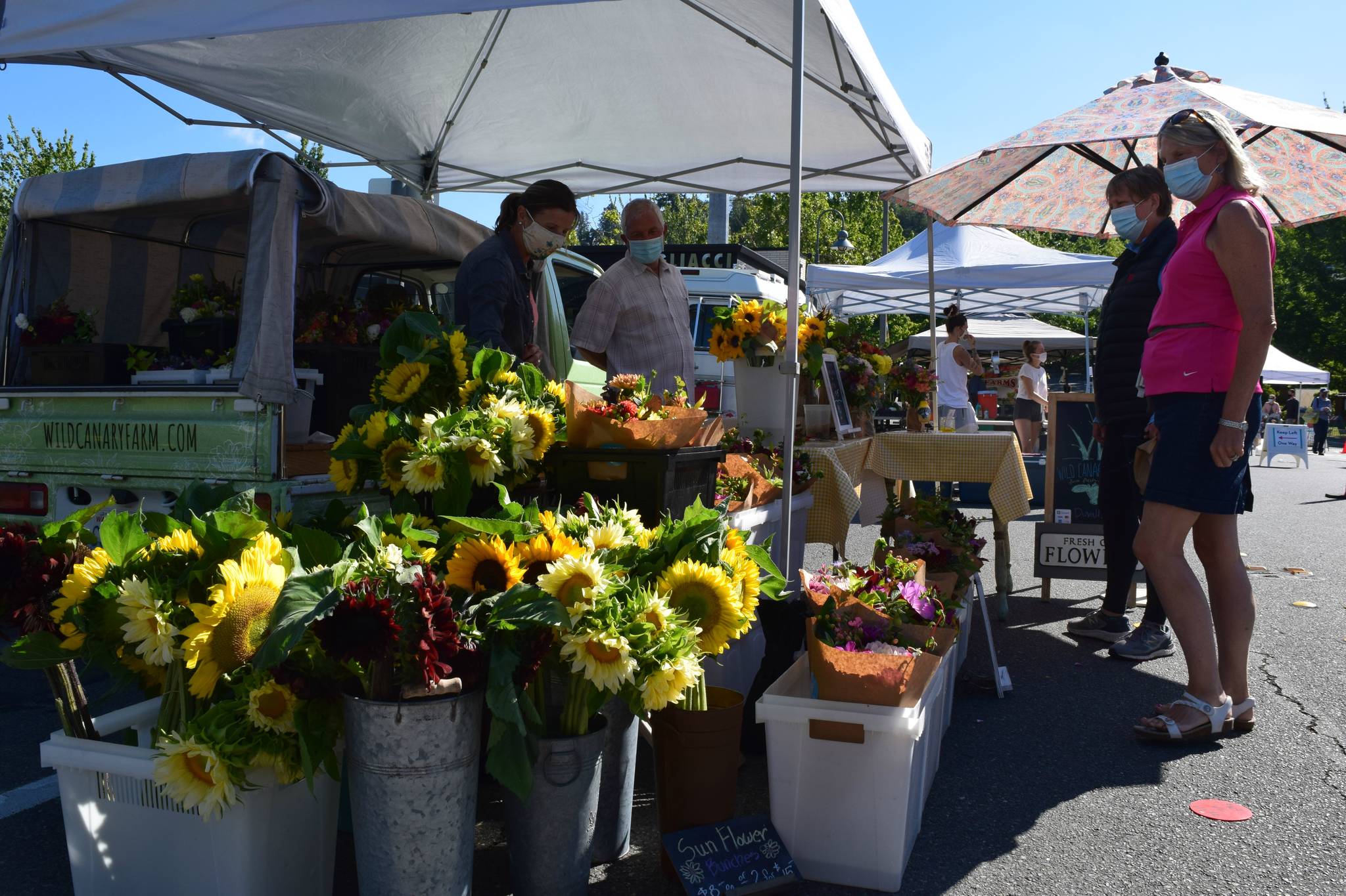 Mercer Island Farmers Market visitors check out flowers on a recent Sunday. Photo courtesy of the Mercer Island Farmers Market
