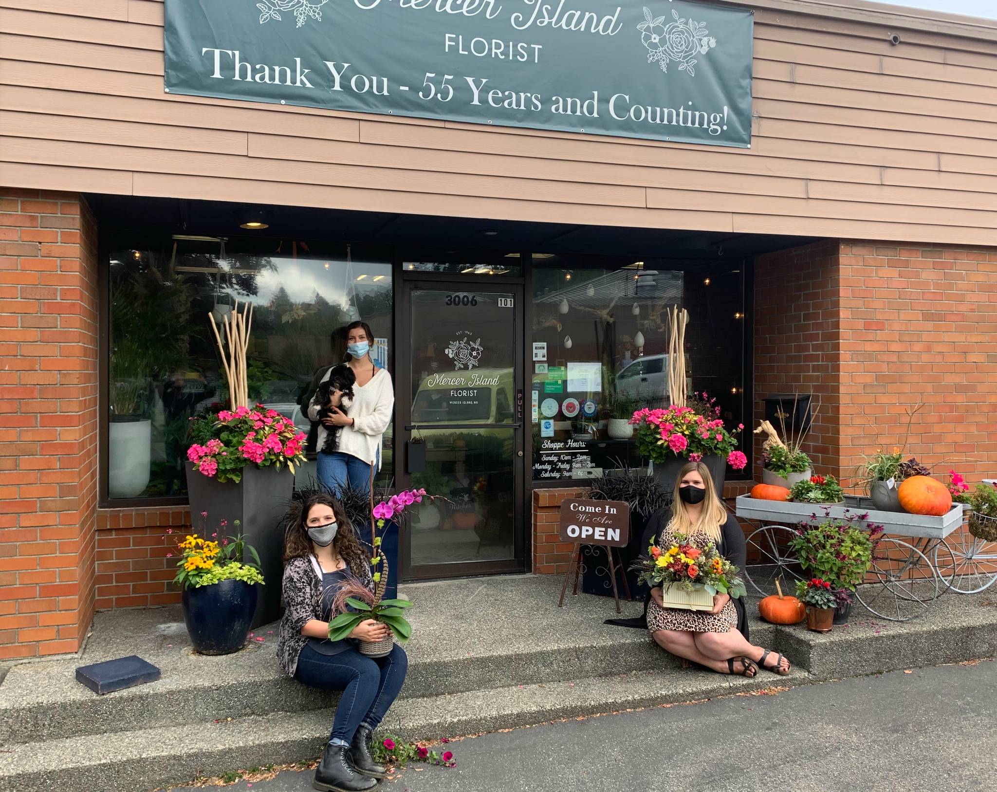 From left to right at Mercer Island Florist, Christina Montilla, business operations and marketing director; Ava Baumgarten, senior shop associate; and Jenna Weischedel, lead designer and shop manager. Black-and-white Havanese Louie is the shop dog. Courtesy photo
