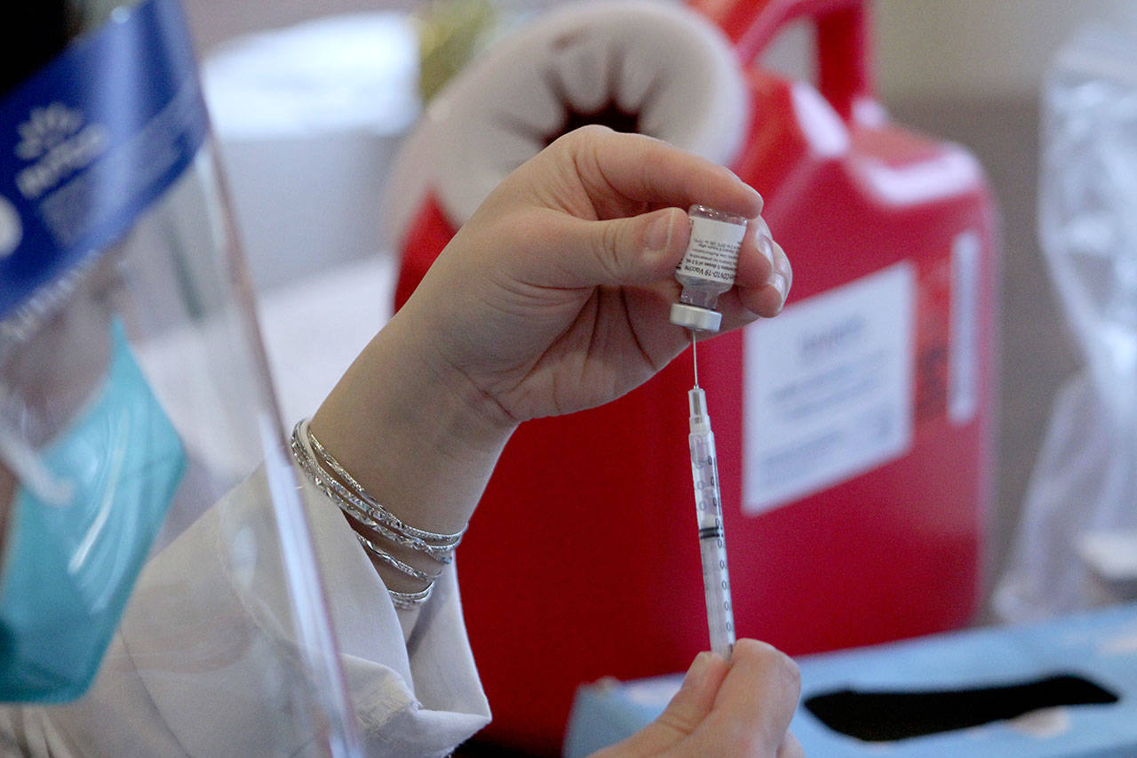 A CVS pharmacist prepares a shot of the Pfizer-BioNTech COVID-19 vaccine. File photo