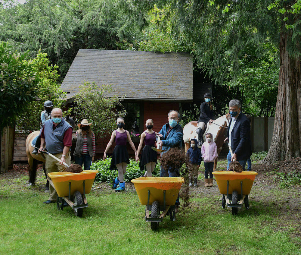 From left, Gary Redman of Redman Construction, Inc., Mercer Island Mayor Benson Wong and Mercer Island City Councilmember Craig Reynolds shovel dirt at the groundbreaking ceremony on May 6 for the restoration of the old Lakeview Schoolhouse’s teacher’s cottage, which caught fire in 2018. Andy Nystrom/ staff photo