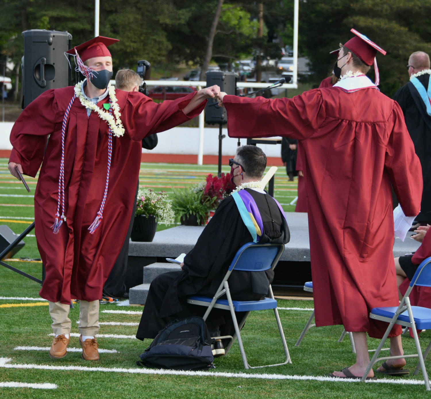 Mercer Island High School graduates fist bump during the class of 2021’s ceremony on June 10 at Islander Stadium. Andy Nystrom/ staff photo
