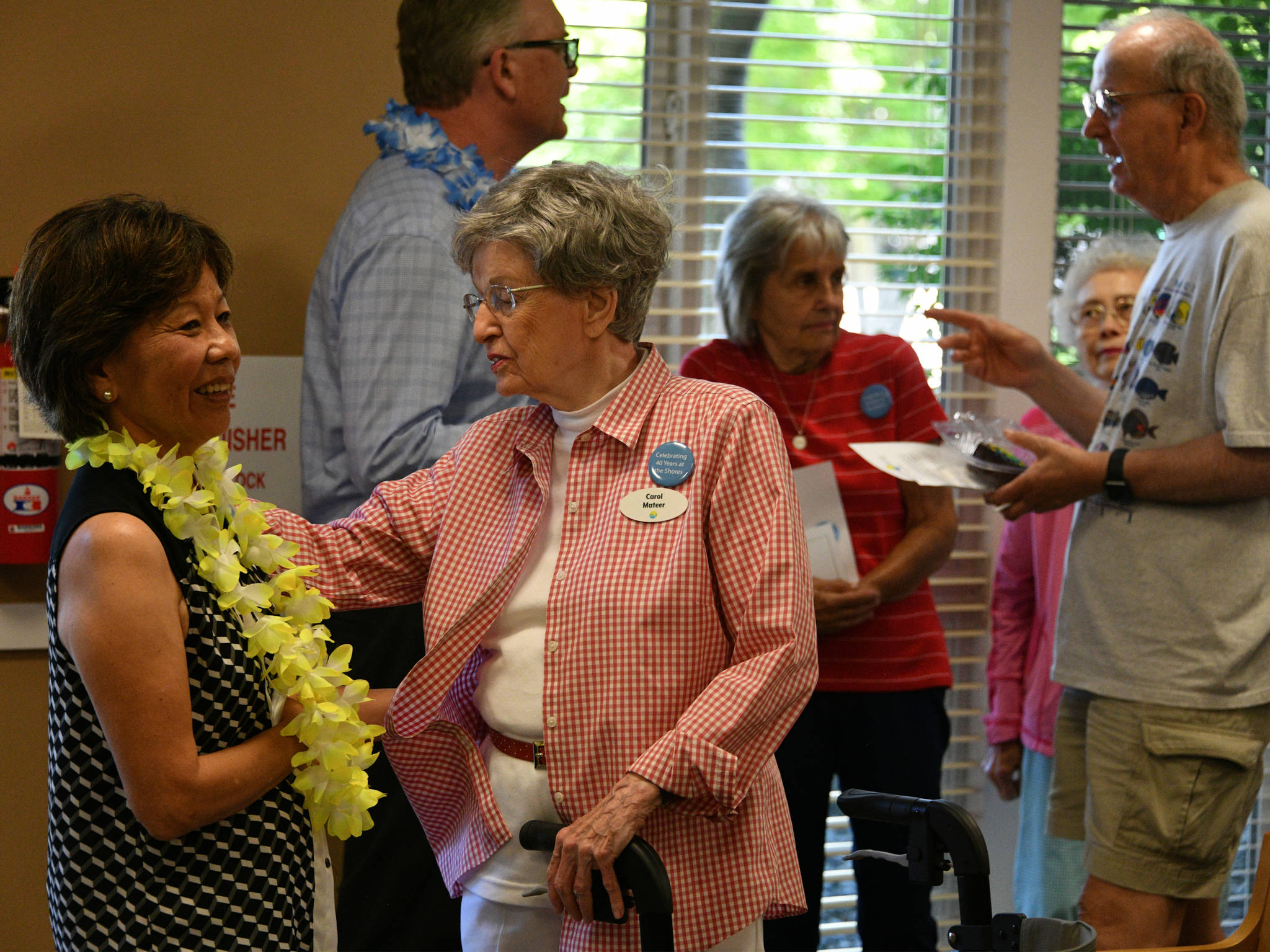 Former administrator Anne Arakaki Lock, left, visits with resident Carol Mateer at the Covenant Living at the Shores 40th anniversary celebration on June 21. Andy Nystrom/ staff photo