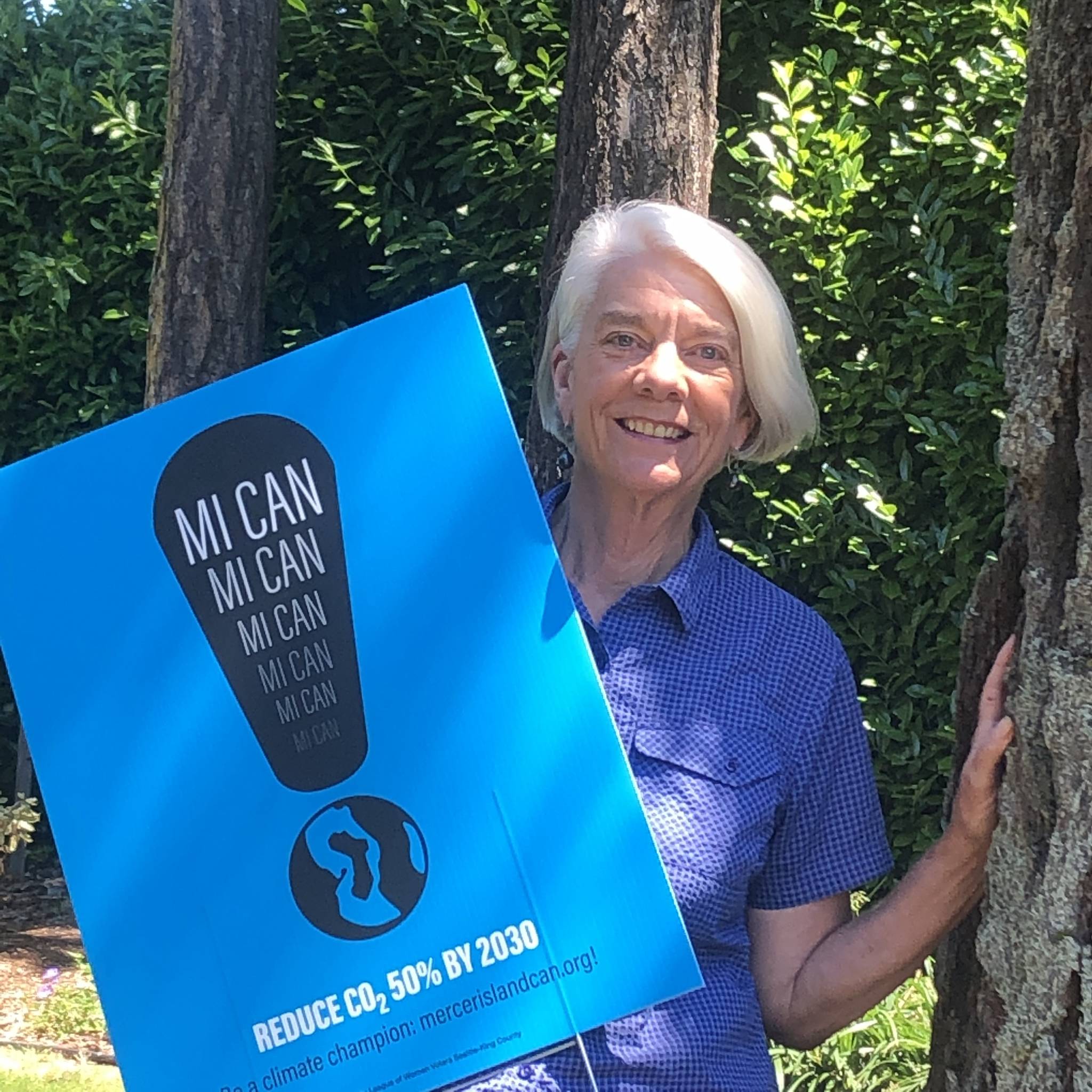 Callie Ridolfi displays one of the Mercer Island Climate Action Now (MI CAN) signs that have been widely distributed on the Island. Photo courtesy of Bruno Ridolfi