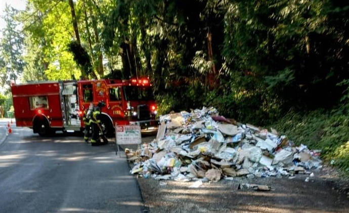 A Recology recycling truck called the Mercer Island Fire Department for emergency assistance on the morning of July 23 after the vehicle’s load caught fire. Fire crews coordinated with the driver to safely unload the materials onto the ground so they could extinguish the fire. This process occurred so the Recology truck didn’t catch fire and potentially spill fuel and burning toxic materials. A professional cleanup crew was soon on the scene. Photo courtesy of the Mercer Island Fire Department