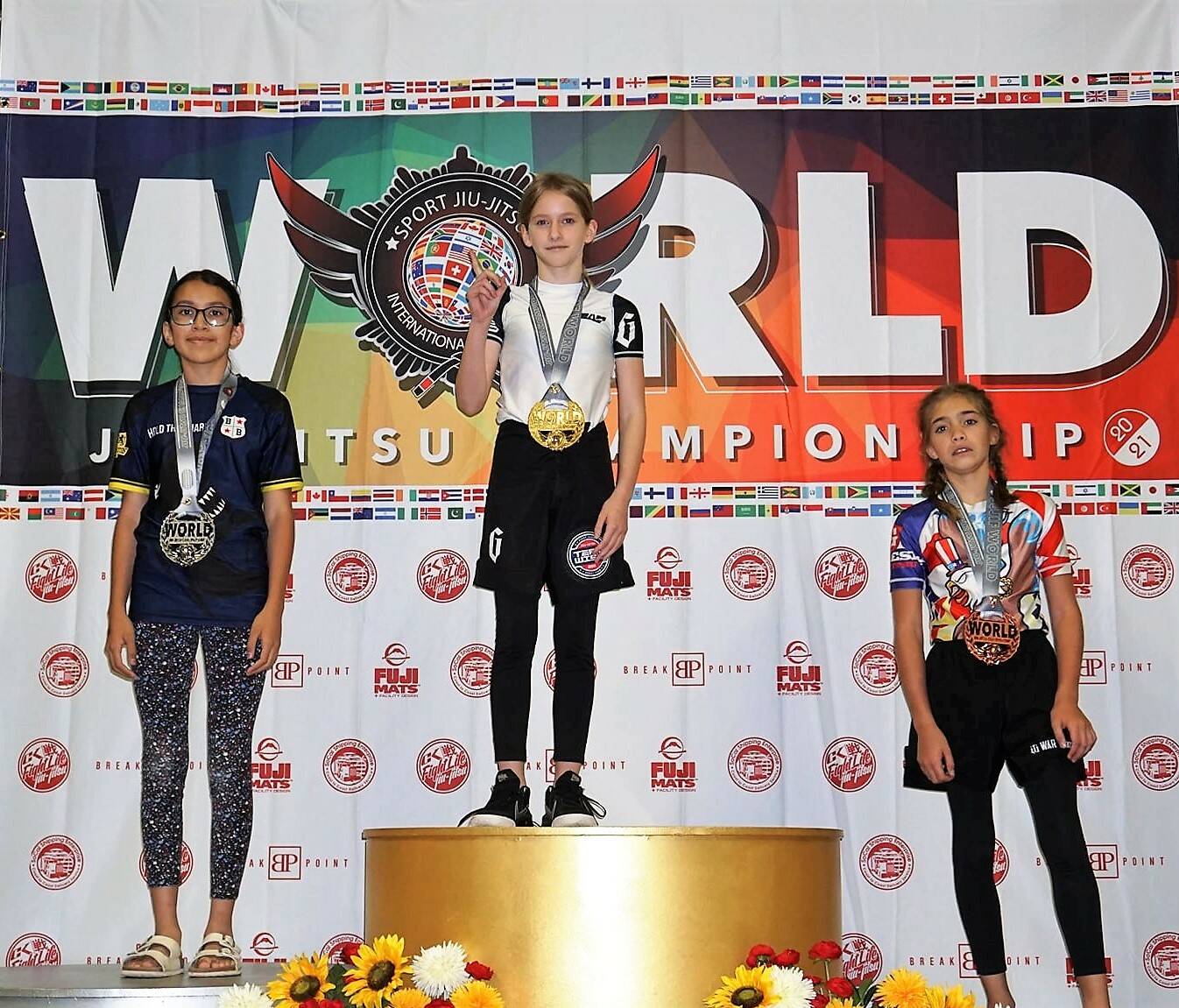 Maggie Gibson, center, stands atop the victory podium at the Sport Jiu Jitsu International Federation (SJJIF) World Championships in Dallas, Texas, on Oct. 30. Photo courtesy of the SJJIF