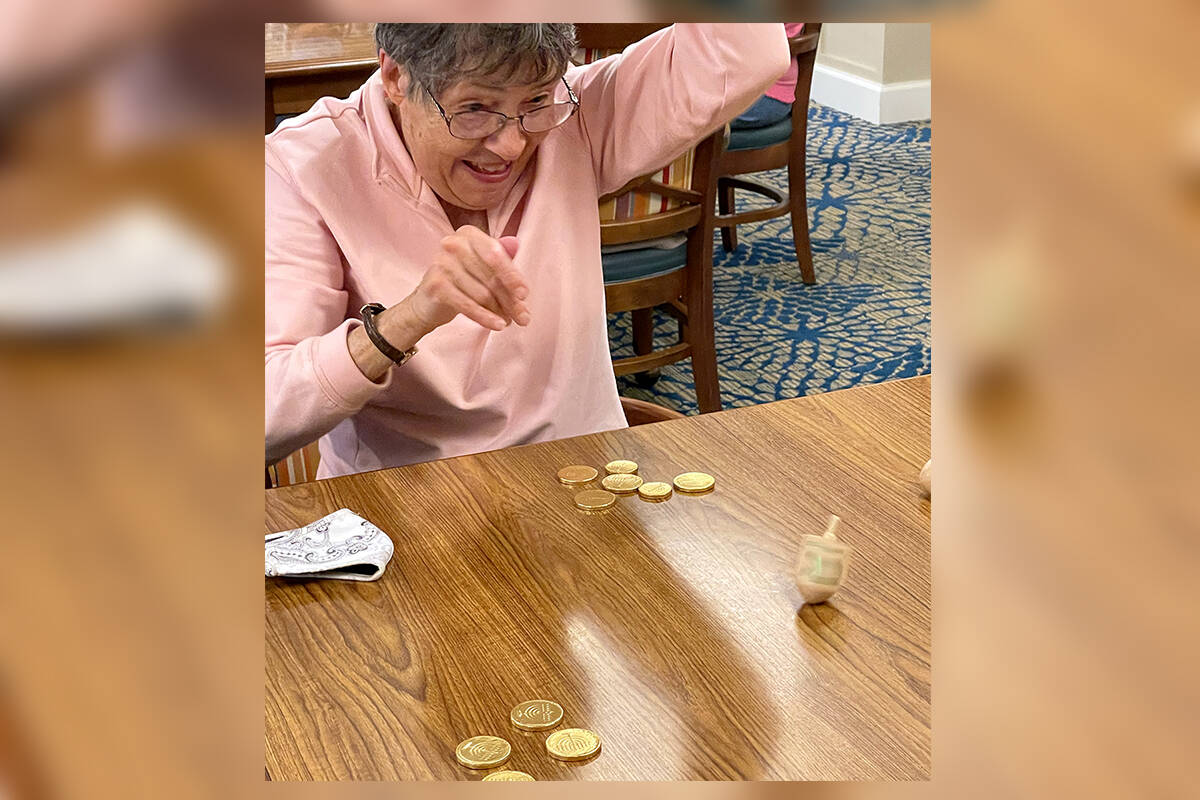 Island House resident Storm Yanicks playing the Dreidel Game during a recent Hanukkah celebration.