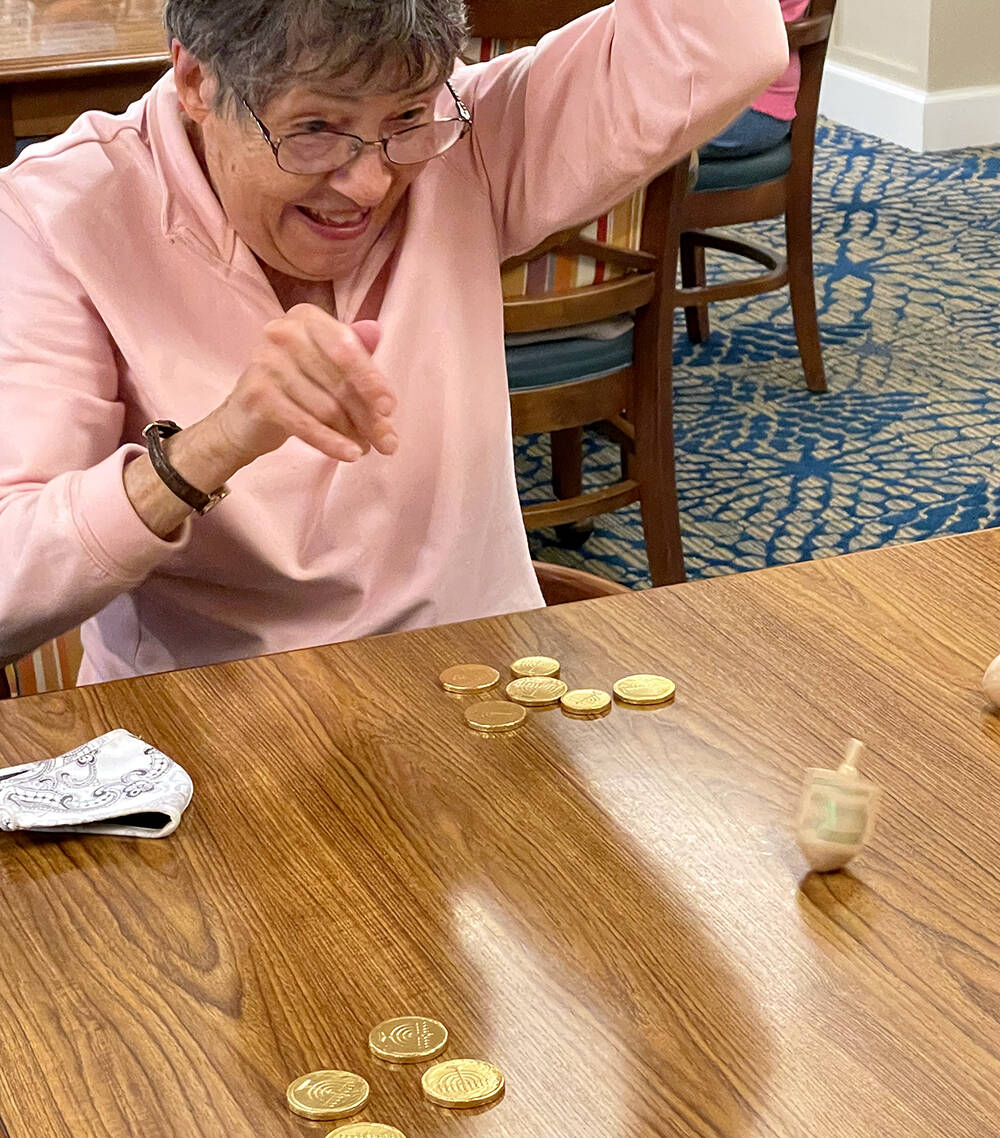 Island House resident Storm Yanicks playing the Dreidel Game during a recent Hanukkah celebration.