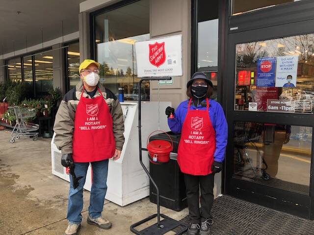 Every holiday season, the Rotary Club of Mercer Island encourages donations to The Salvation Army. This year, club volunteers are ringing the bells the three Saturdays before Christmas, making it easy to contribute on the way in or out of grocery shopping on the Island. Pictured are Mayor Benson Wong and his wife Terry Mark on Dec. 4 at QFC. They have both been regular volunteers since joining the club. Courtesy photo