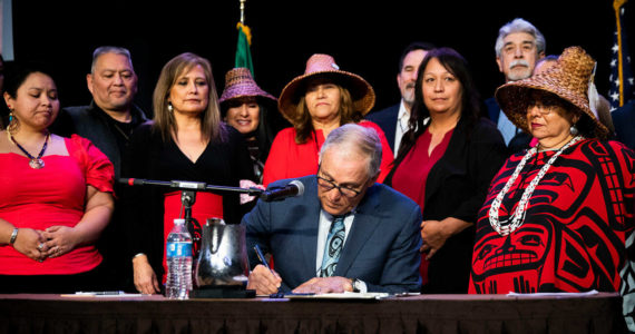 Tulalip council members and tribal members watch as Governor Jay Inslee signs bill HB 1571 into law at the Tulalip Resort on Thursday, March 31, 2022 in Tulalip, Washington. (Olivia Vanni / The Herald)