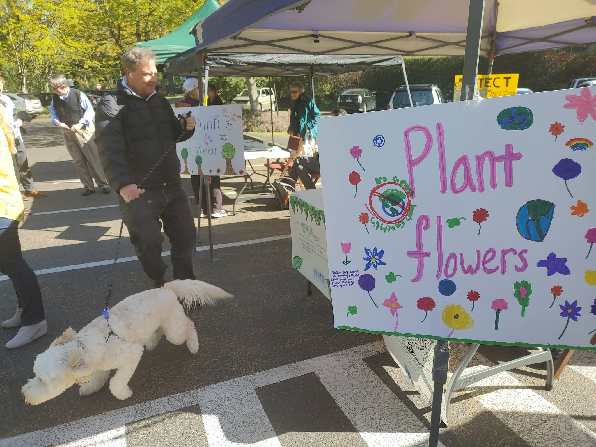 Earth Day Fair attendees, including a pet, soak up the sun on April 22 at the Congregational Church on Mercer Island. Andy Nystrom/ staff photo