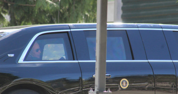 A man who appears to be President Joe Biden is seen in the back seat of a car in the president’s motorcade, departing the Green River College after the president’s speech. Photo by Alex Bruell/Sound Publishing