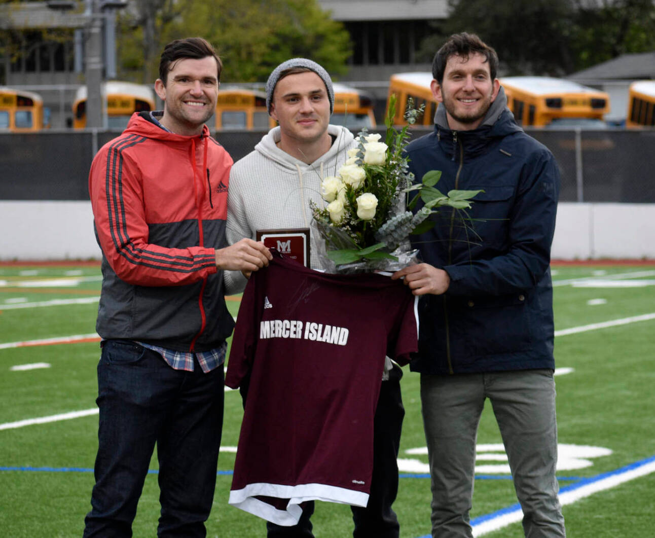 Former Mercer Island High School boys soccer head coach Colin Rigby, left, Jordan Morris, center, and Islanders boys soccer head coach Forrest Marowitz pose for a quick photo on April 23, 2019, at Islander Stadium. Morris was inducted into the Mercer Island High School Athletic Hall of Fame. Photo courtesy of Kim Otte