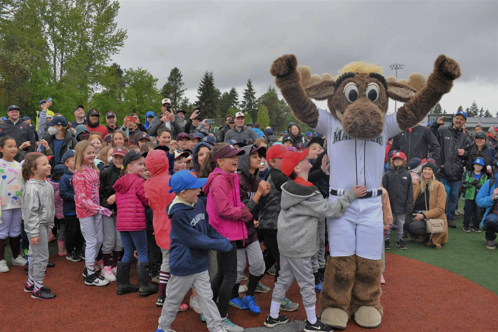 Players gather around the Mariner Moose at the Boys and Girls Club of Mercer Island’s annual Little League Opening Day on May 7 at the South Mercer Fields. Mercer Island resident and Mariners general manager Jerry Dipoto was the guest speaker. There were 50-plus teams, ranging in ages from 3-12, who marched in the parade and were greeted by the Mercer Island High School baseball and fastpitch softball teams. Courtesy of Kym Otte