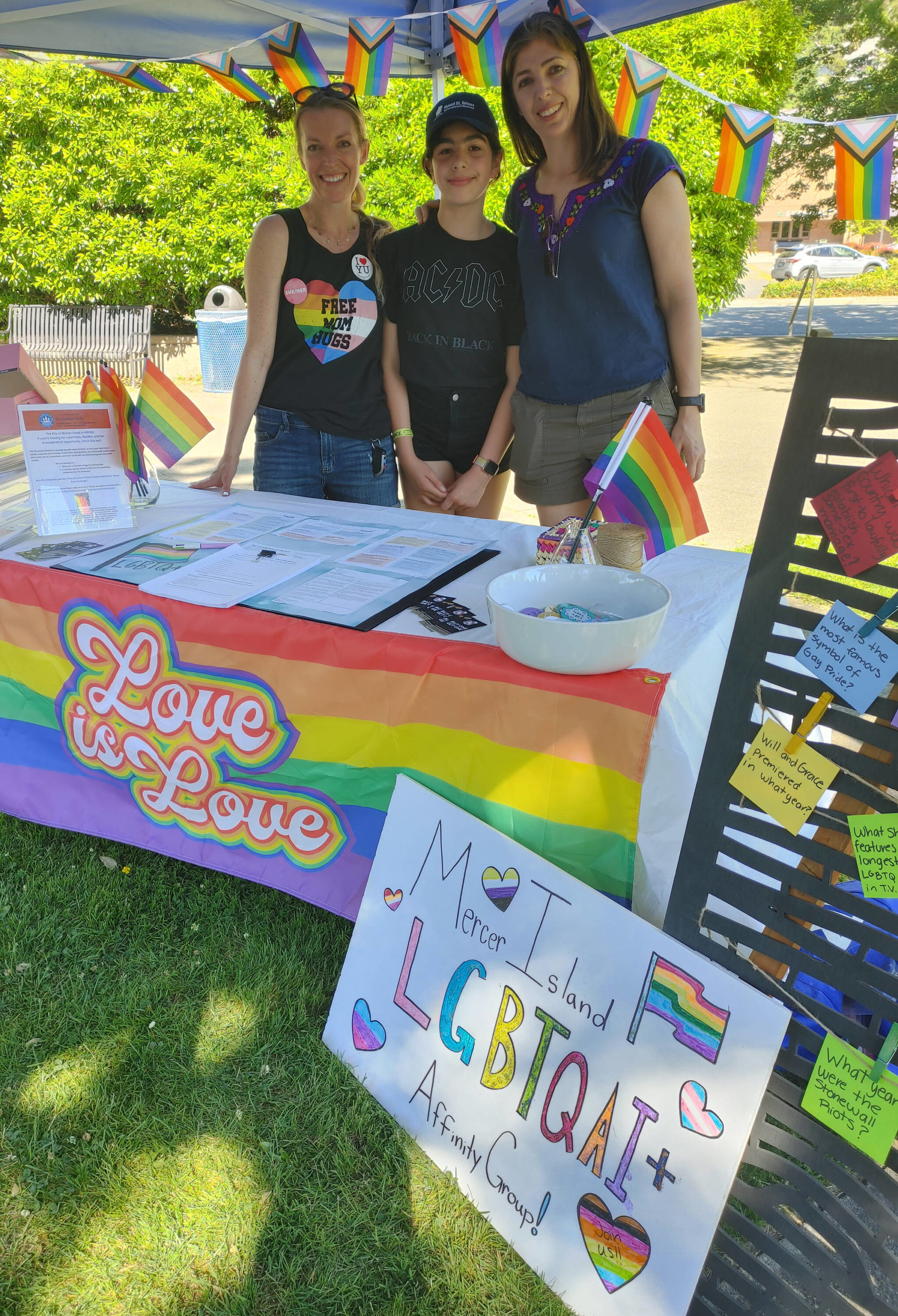 LGBTQ+ Families Affinity Group members, from left, Jaymee Lundin, Pia Santana and Cristina Martinez stand at their booth during the Mercer Island Pride Celebration on June 26. Andy Nystrom/ staff photo