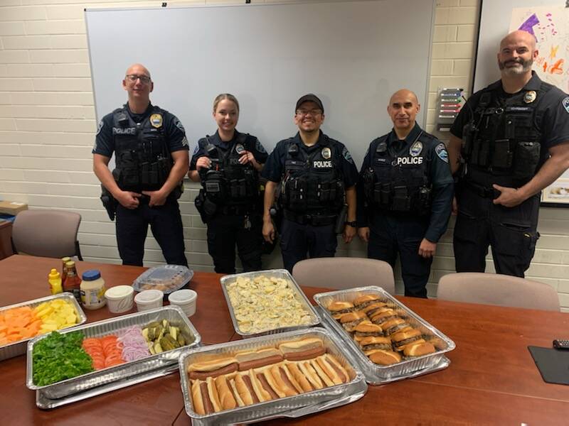 From left to right, Mercer Island Police Department’s sergeant Dominic Amici, officer Jacqueline Dawson, officer Luis Paz, officer Art Munoz and sergeant Scott Schroeder receive a Fourth of July lunch from thankful residents. Eleven officers were on duty that day, including three Marine Patrol units on the water. Photo courtesy of corporal Bobby Jira