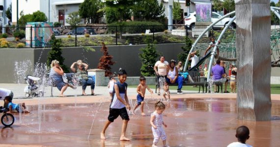 Families splash and play in the water at at Federal Way’s Town Square Park to cool off from a previous heatwave in the region. (Sound Publishing file photo)