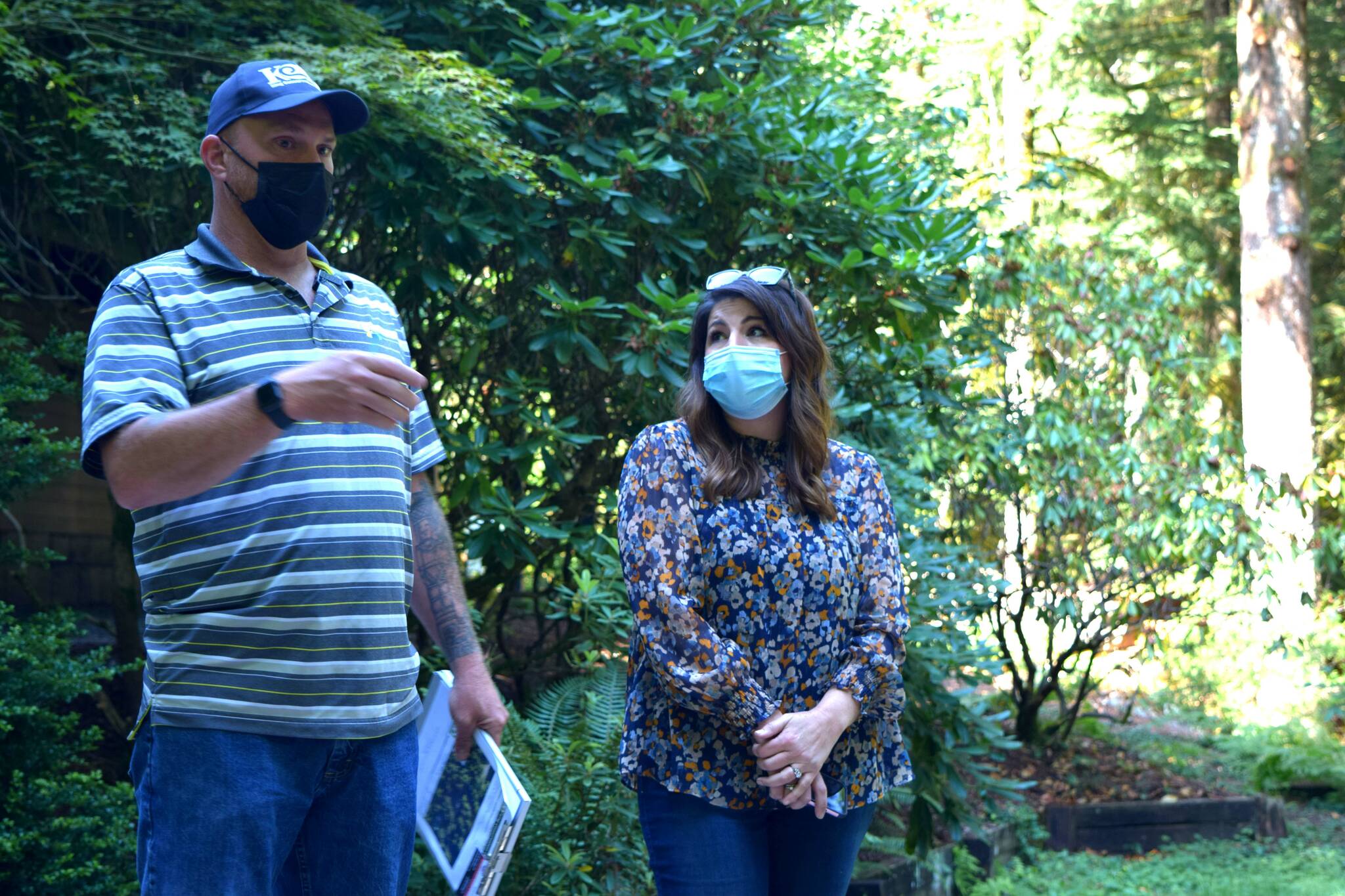 Matt Axe, the Wildfire and Forest Resiliency Coordinator with the King County Conservation District, speaks to homeowner Anita Kissee-Wilder about fire reduction strategies at her home in North Bend on Aug. 24, 2021. Photo by Conor Wilson/Valley Record