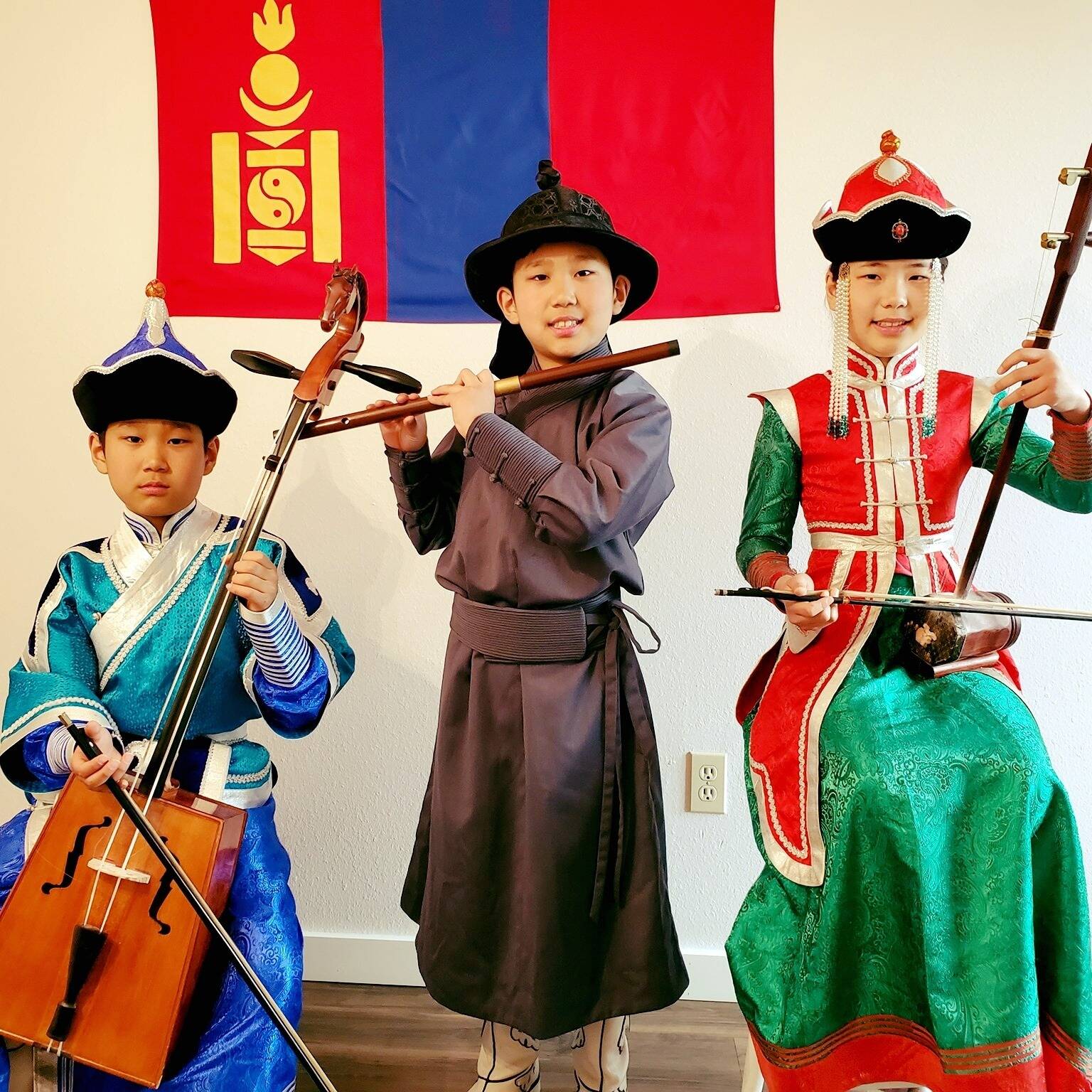Courtesy photo
From left, Temuujin, Temuulen and Anu-Ujin Batbaatar dress in traditional Mongolian costumes while holding their instruments.