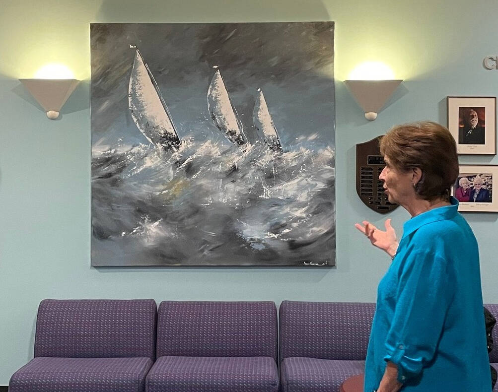 Jane Meyer Brahm of the Mercer Island Sister City Association discusses a painting displayed in city hall that Mercer Island received from its sister city, Thonon-les-Bains in France. Photo courtesy of the city of Mercer Island