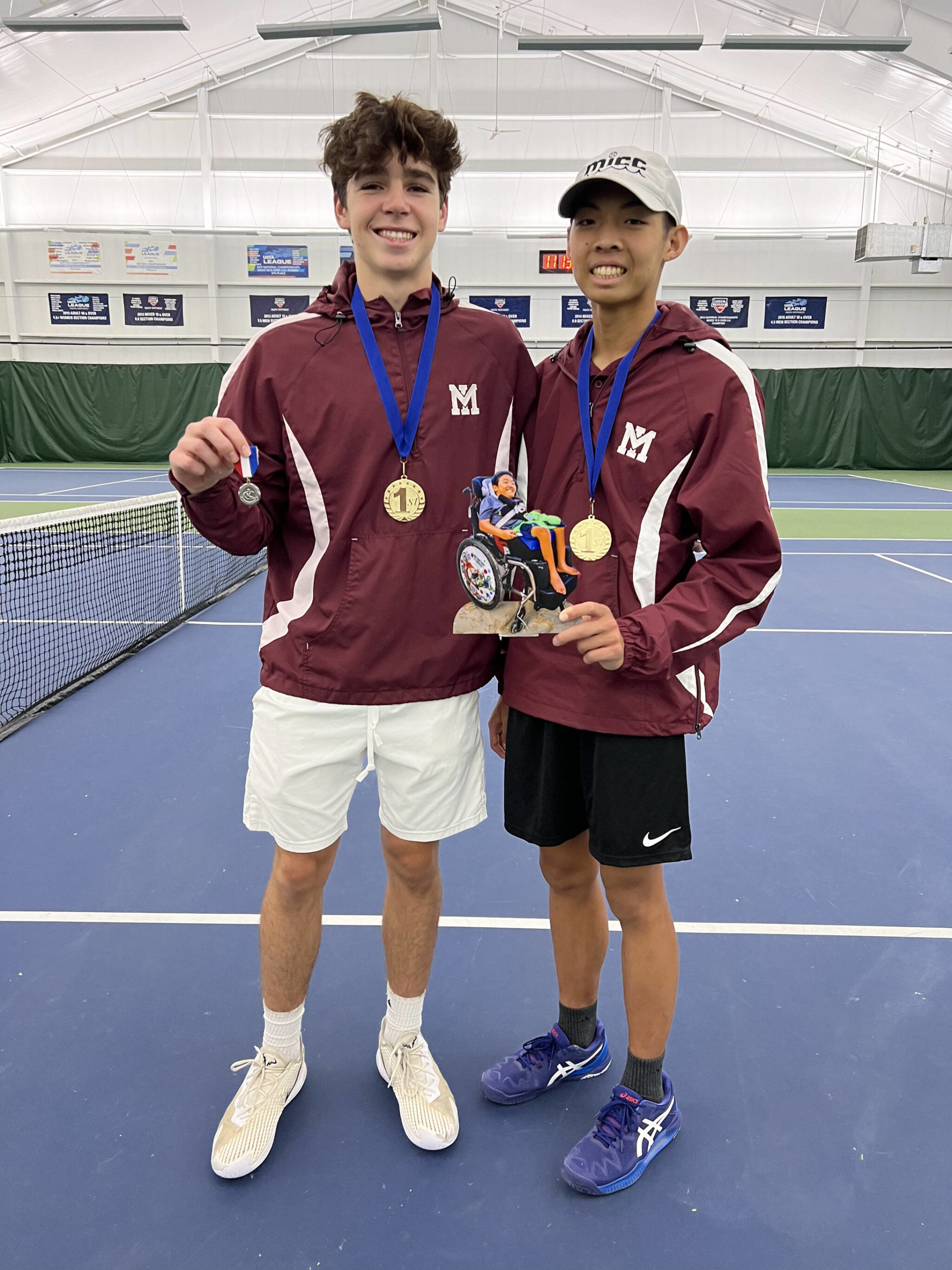 Sam Dilworth, left, and his tennis doubles partner Connor Leung hold a statuette of Aidan Leung, who passed away last May. The Mercer Island High School duo notched first place at the 3A KingCo tournament. Courtesy photo