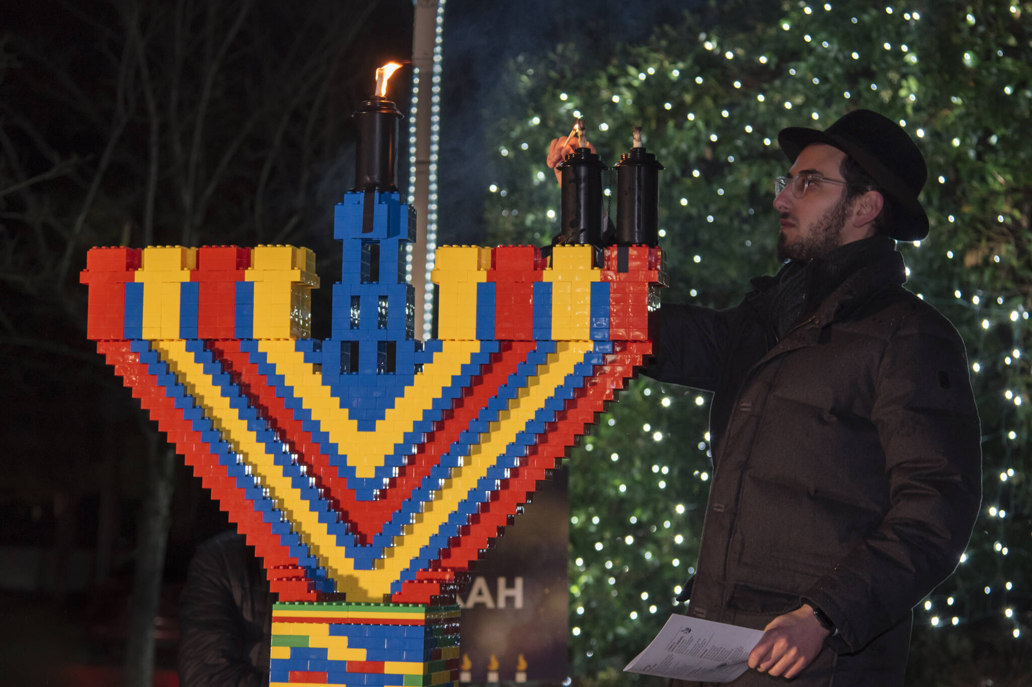Rabbi Nissan Kornfeld of Chabad Mercer Island lights a six-foot Lego Hanukkah menorah on Dec. 19 at Mercerdale Park. Photo courtesy of Ariella Cohen