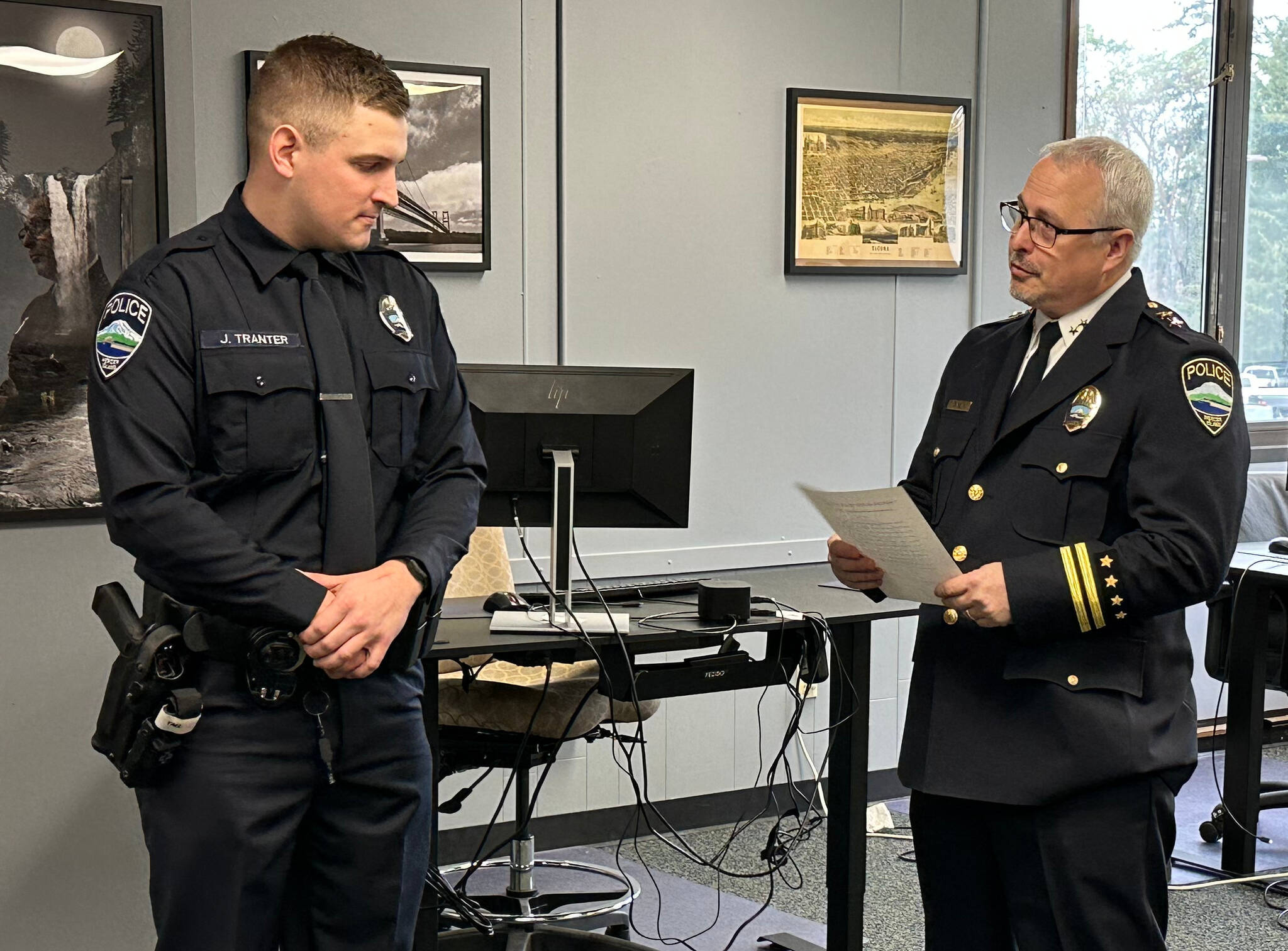 New Mercer Island Police Department officer Jordan Tranter graduated from the law enforcement academy and was sworn in by commander Jeff Magnan on Feb. 6 as police chaplain Greg Asimakoupoulos looked on. The chaplain was a college classmate of Tranter’s father 50 years ago. Photo courtesy of Greg Asimakoupoulos