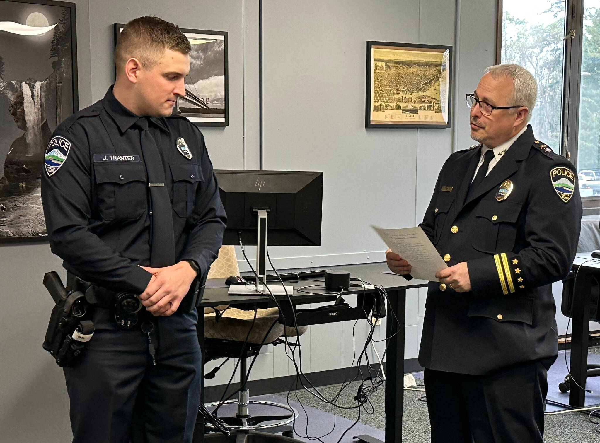 New Mercer Island Police Department officer Jordan Tranter graduated from the law enforcement academy and was sworn in by commander Jeff Magnan on Feb. 6 as police chaplain Greg Asimakoupoulos looked on. The chaplain was a college classmate of Tranters father 50 years ago. Photo courtesy of Greg Asimakoupoulos
