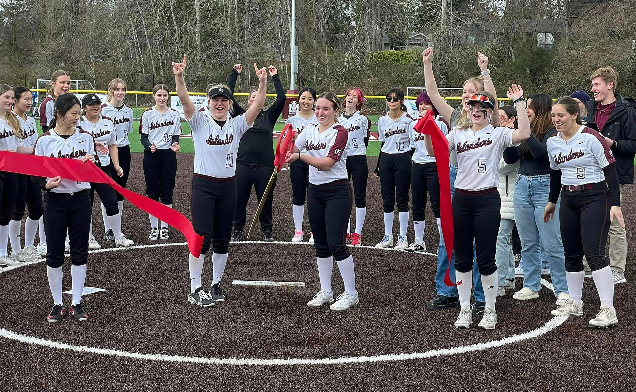 Mercer Island High School (MIHS) fastpitch softball players joyfully cut the ribbon at the recently renovated South Mercer Playfields on March 11. Mercer Island School District and the city of Mercer Island held the event and district student board representatives Andrew Howison and Asha Woerner hosted the ceremony, which took place during a 16-team MIHS fastpitch softball jamboree. District Superintendent Fred Rundle, Mayor Salim Nice, softball captain Caley Newcomer and softball head coach Amanda Mattocks addressed the large crowd that attended the event. The three ball fields and auxiliary field were enhanced with new turf and lighting. Photo courtesy of the Mercer Island School District