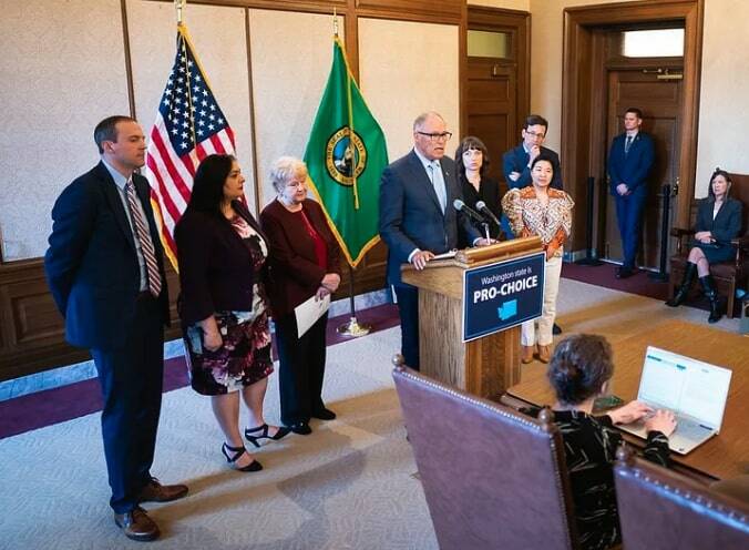 From left to right: Rep. Marcus Riccelli, Sen. Manka Dhingra, Sen. Karen Keiser, Gov. Jay Inslee, Rep. Jessica Bateman, Rep. My-Linh Thai and AG Bob Ferguson. (Courtesy photo)