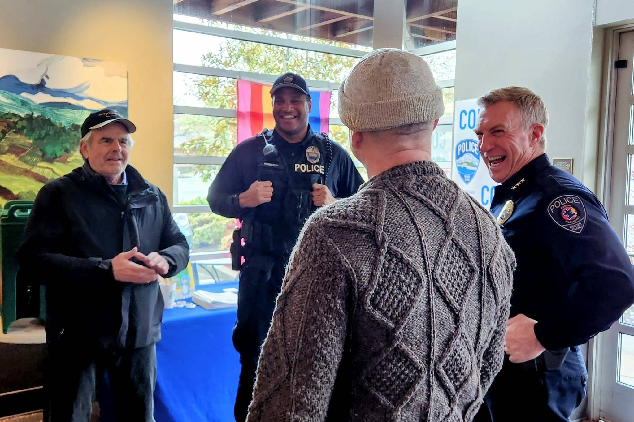Mercer Island Police Department Chief Ed Holmes, right, and officer Kelly Robinson share a laugh with two residents at the April 10 Coffee With A Cop event at the north-end Starbucks. For the events, Robinson coordinates the venue and schedule and outreach materials. Photo courtesy of the Mercer Island Police Department