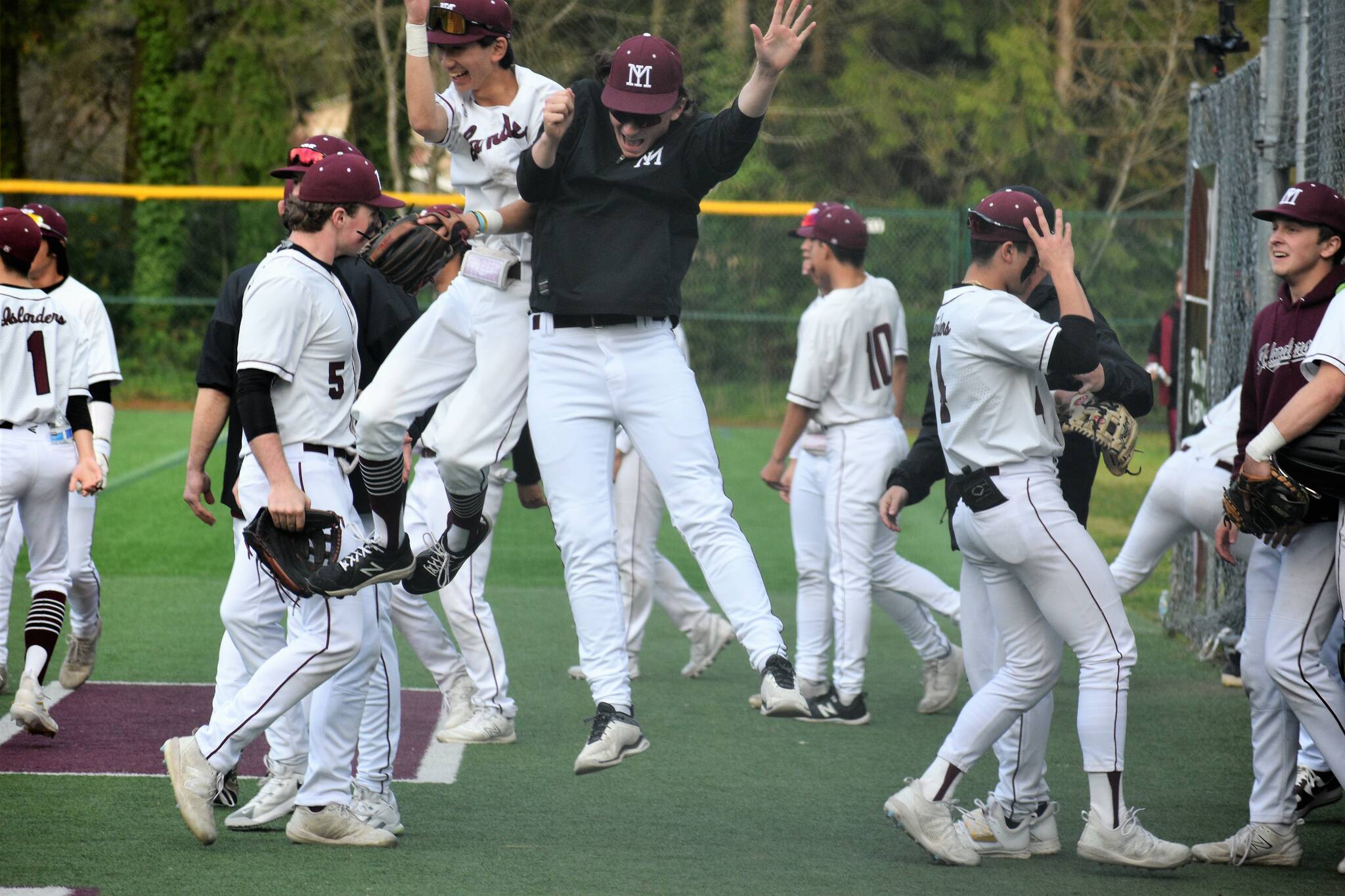 Mercer Island High School (MIHS) player Shane Deguchi and coach Garrett Poore (both center) celebrate the final out in the Islanders 3-0 baseball victory over Lake Washington High School on April 26 at Island Crest Park. Both teams share the 3A KingCo title with 10-2 records and will begin play in the league tournament on May 6 at Bannerwood Park in Bellevue. Earlier in the season, all teams drew straws in case of a tie and LW won the draw and is the No. 1 seed in the tournament and MIHS will get the second seed. At the MIHS Fan Appreciation and Alumni Night on April 26, school Class of 1985 alumnus and former pro pitcher Dave Wainhouse threw out the honorary first pitch. There were at least 300 spectators at the game, an estimated 150 hot dogs and 80 hamburgers sold and many prizes given away such as MIHS Baseball blankets, hats and sweatshirts. Photo courtesy of Kym Otte