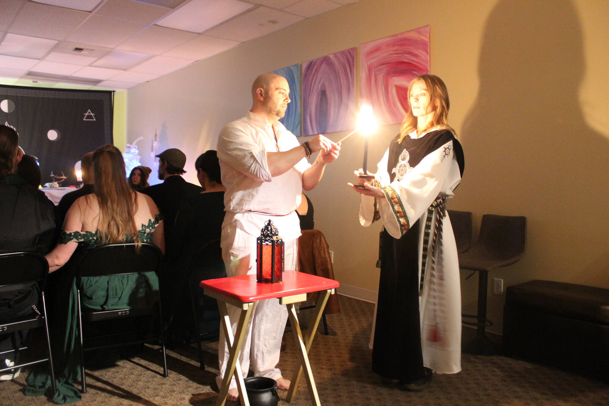 High Priest Kalu and High Preistess Syleena “Call The Corners,” a small ritual where a candle is lit at each direction of the Earth as the elements each direction represents is called upon. Here they call on the guardian of the watchtower of the South, represented by red which symbolizes fire. Photo by Bailey Jo Josie/Sound Publishing.