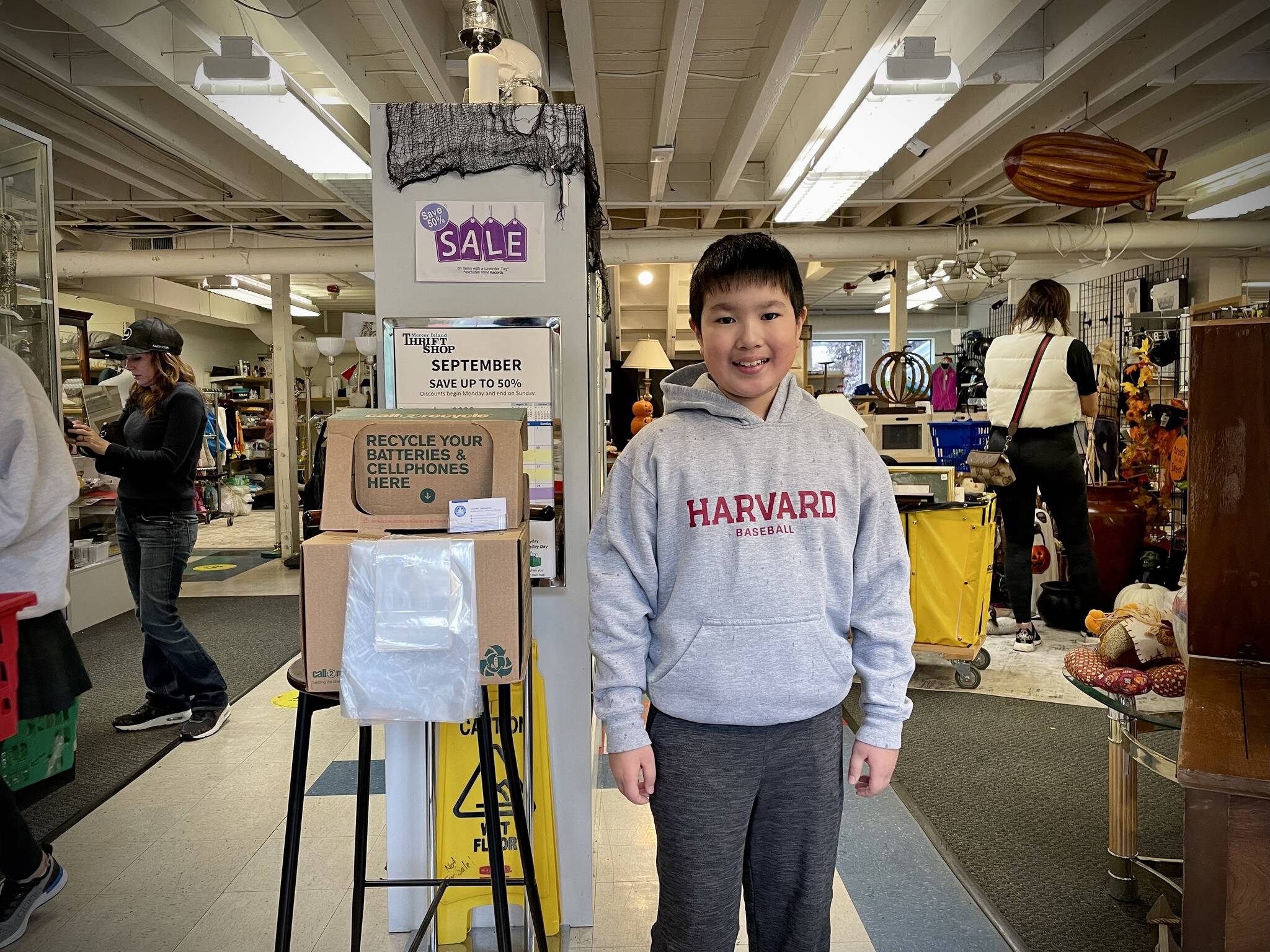 Islander Middle School sixth-grader Bowen Nago stands next to his battery and cellphone collection box inside the Mercer Island Thrift Shop. Photo courtesy of the city of Mercer Island