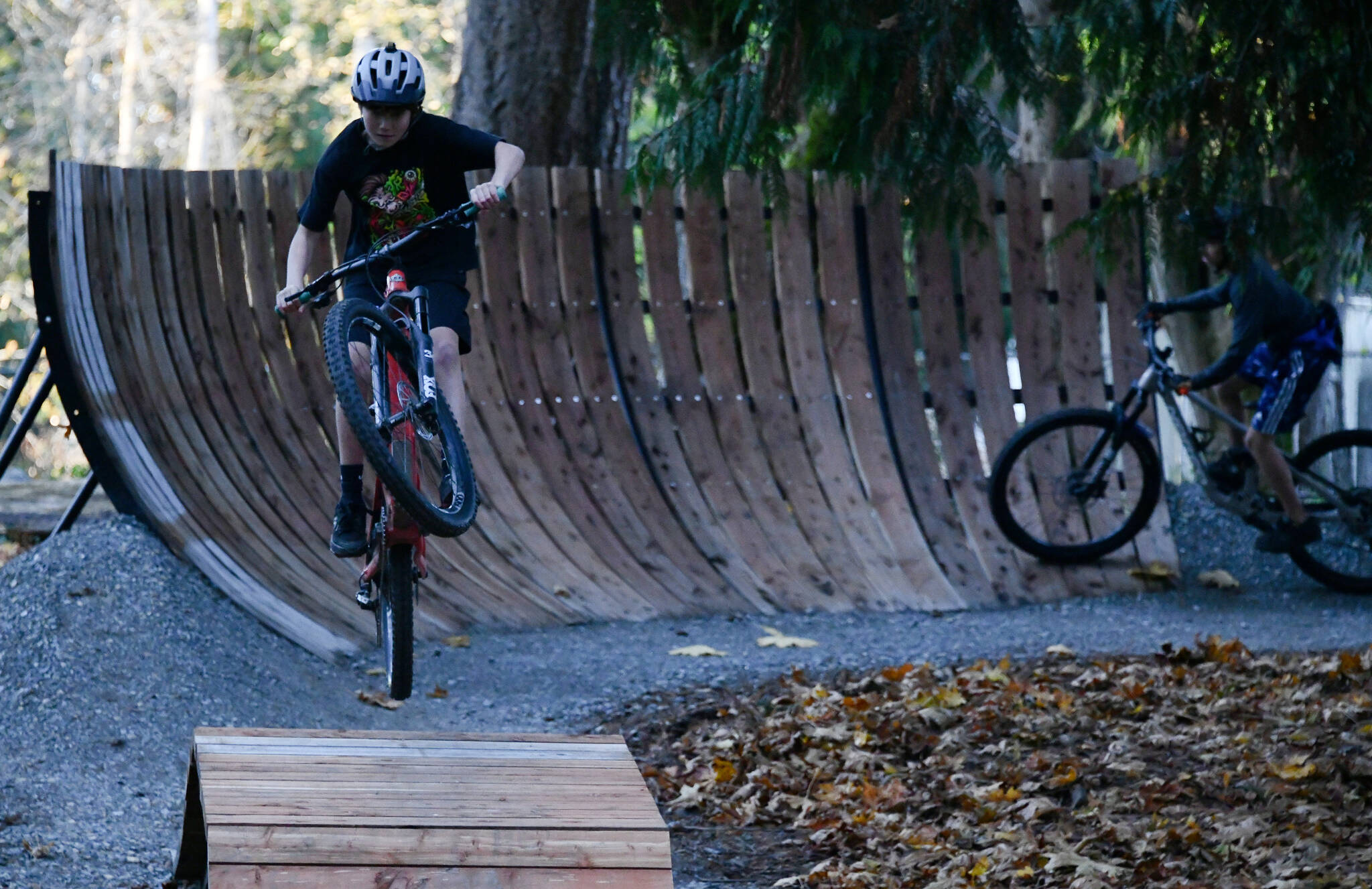 Miles Bailey from the Mercer Island Mountain Bike team gets air while another rider rolls through the new Bike Skills Area, which opened to the public on Nov. 15 at Deane’s Children’s Park. Andy Nystrom/ staff photo