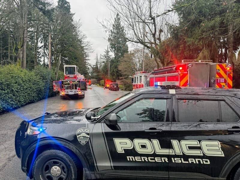 Mercer Island police officers and firefighters with their apparatus cleared the scene of a house blaze off of 84th Avenue Southeast on Jan. 4. No injuries were reported and firefighters had the blaze under control. Eastside Fire & Rescue members and MI’s partners at Seattle Fire Department and Bellevue Fire Department teamed up to control the fire, which is under investigation. Photo courtesy of the Mercer Island Police Department