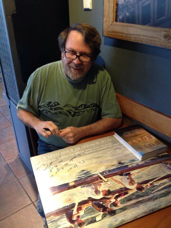 In this 2013 photo, Daniel Brown (author of “The Boys in the Boat”) signs a poster for Greg’s brother Marc, who was a coxswain for the SPU crew team in the 1970s. (Photo courtesy of Greg Asimakoupoulos)