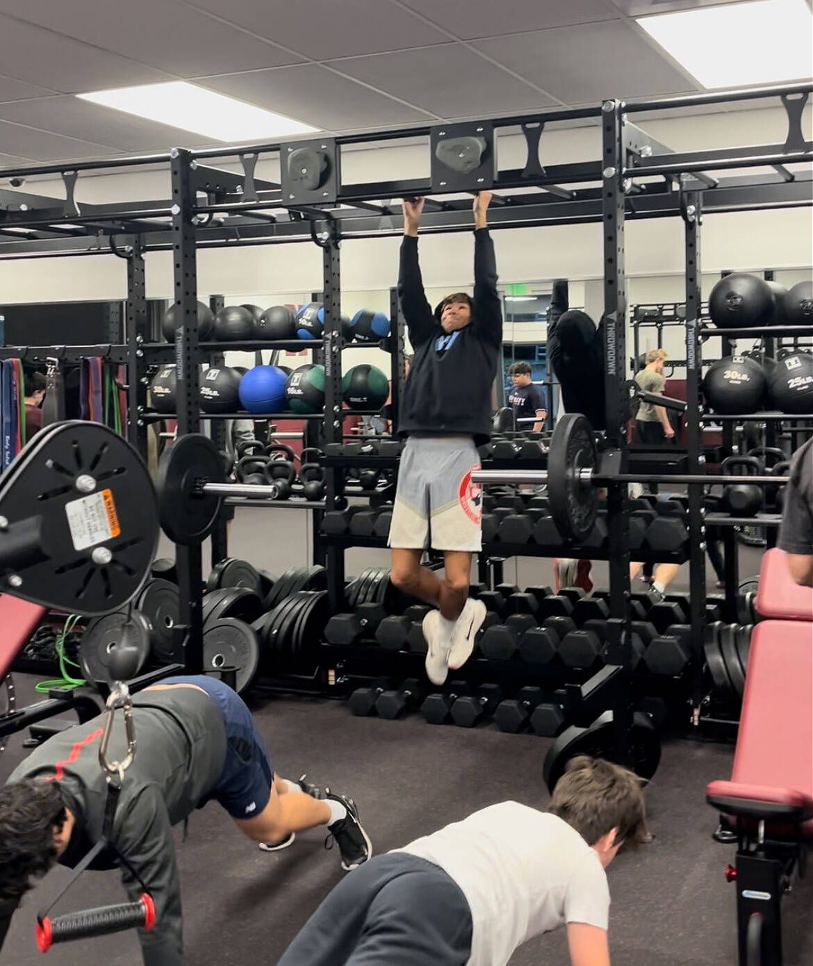 Chase Warnick powers through some pull-ups while other student athletes engage in push-ups at the new fitness center at Mercer Island High School. Courtesy photo