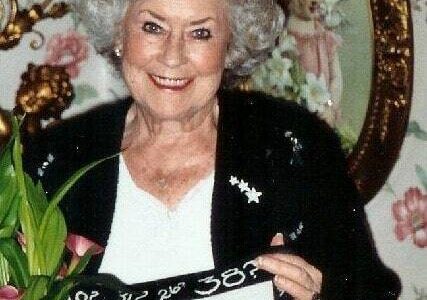 Greg’s late mother holding a pillow with her signature saying. Photo courtesy of Greg Asimakoupoulos