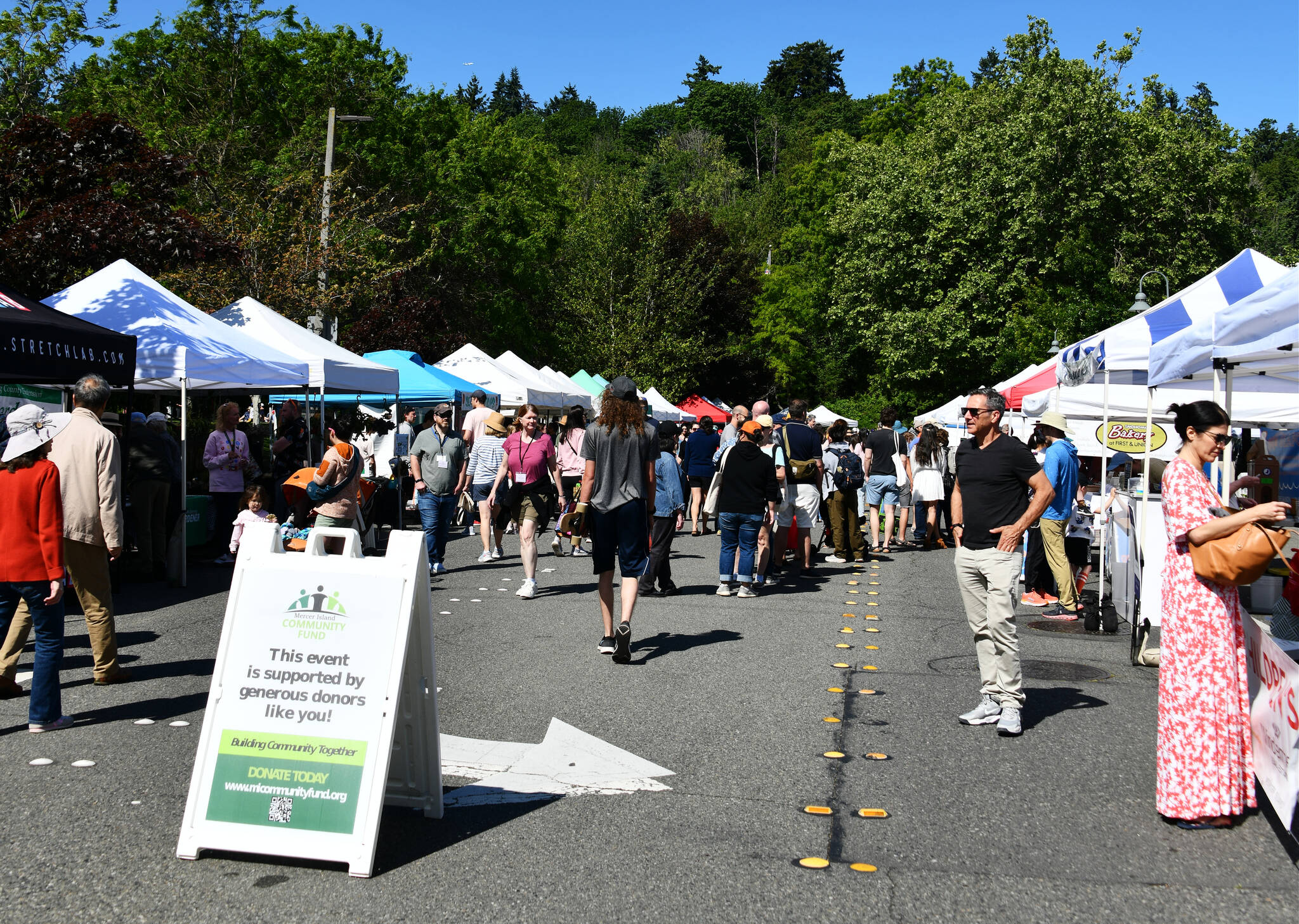 Attendees enjoy the opening day of the Mercer Island Farmers Market on June 4, 2023. Andy Nystrom/ staff photo