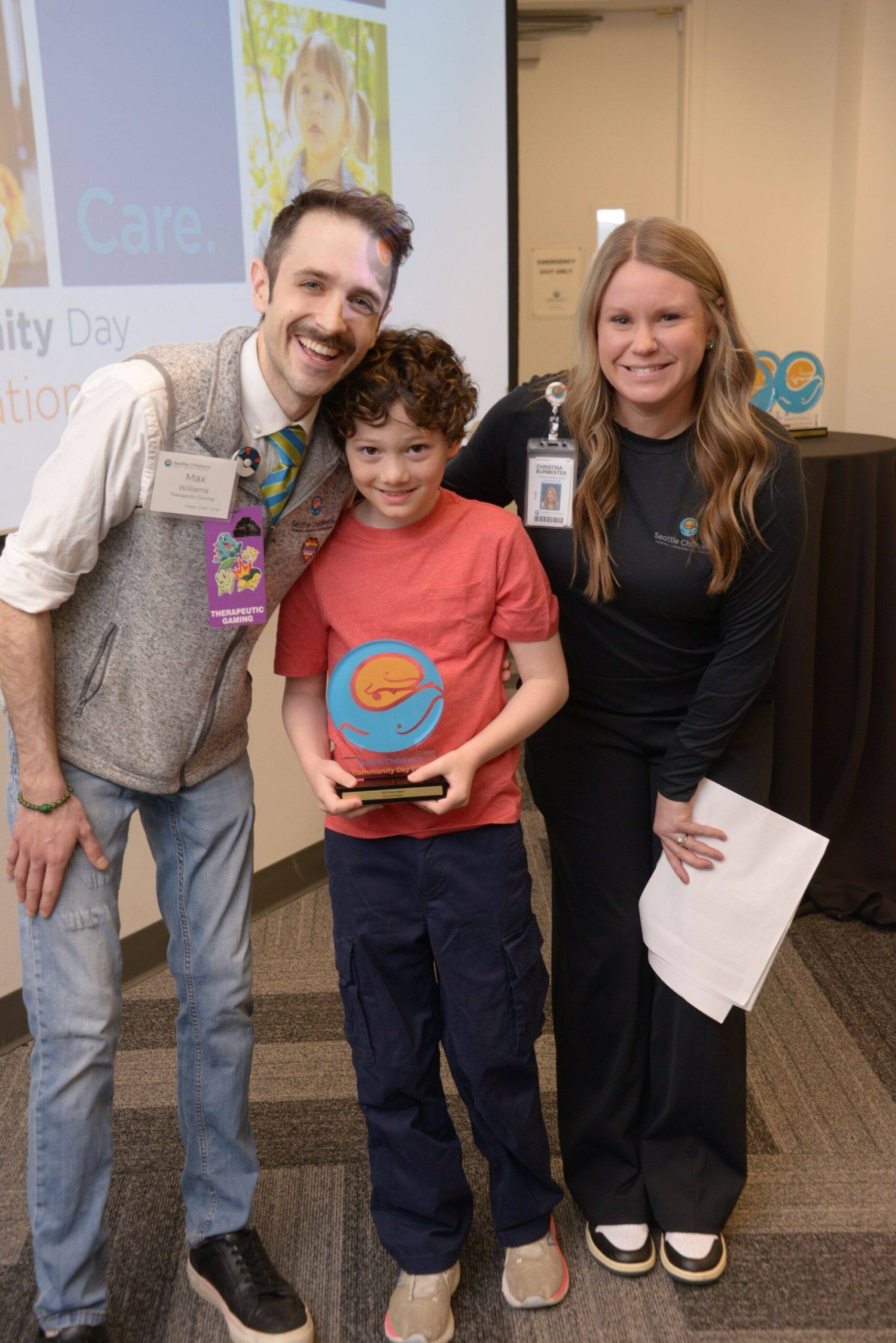 Mercer Island’s Emerson Vivion, center, displays his Seattle Children’s Hospital Community Day Hope award alongside Max Williams (Therapeutic Gaming Program specialist with Child Life) and Christina Burmester (Seattle Children’s Foundation development coordinator, community giving). Courtesy photo