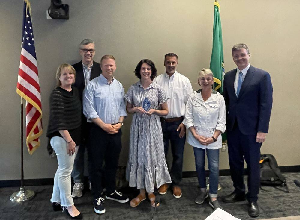 Mercer Island’s 2024 Community Member of the Year Jennifer Goodrich, center, gathers with Mercer Island City Council’s Wendy Weiker, Craig Reynolds, Deputy Mayor David Rosenbaum, Mayor Salim Nice, Lisa Anderl and Ted Weinberg. Photo courtesy of the city of Mercer Island