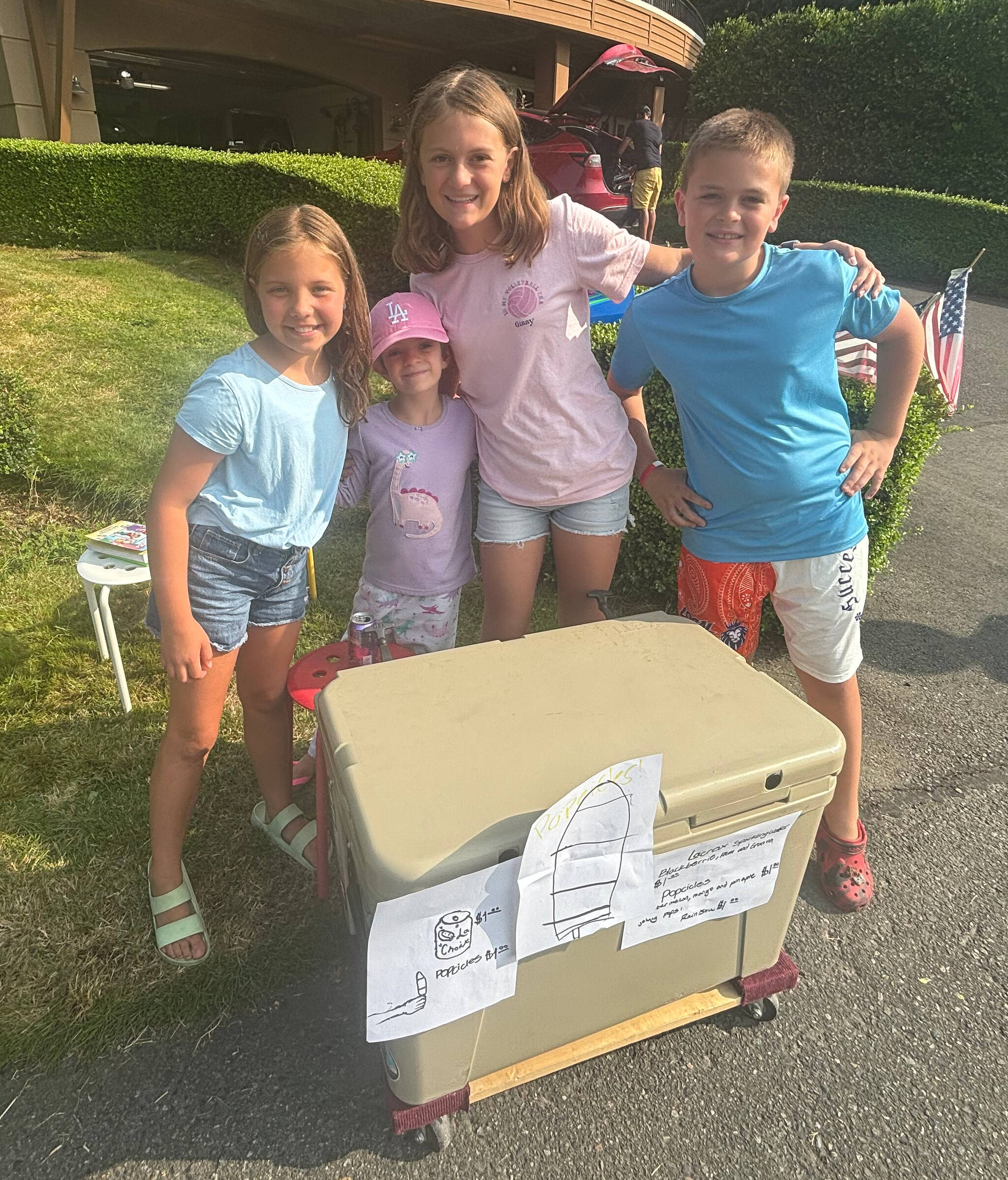 From left to right, Elsie Roeter, Lulu Rourke, Ginny Rourke and Baker Rourke sell popsicles and sparkling water for $1 each on Aug. 1 with funds going to Seattle Children’s Hospital. They sold the items in front of the Rourkes’ house near Aubrey Davis Park where people watched the Blue Angels’ Seafair airshow. The kids were planning on continuing their fundraiser on Saturday and maybe Sunday. Andy Nystrom/ staff photo