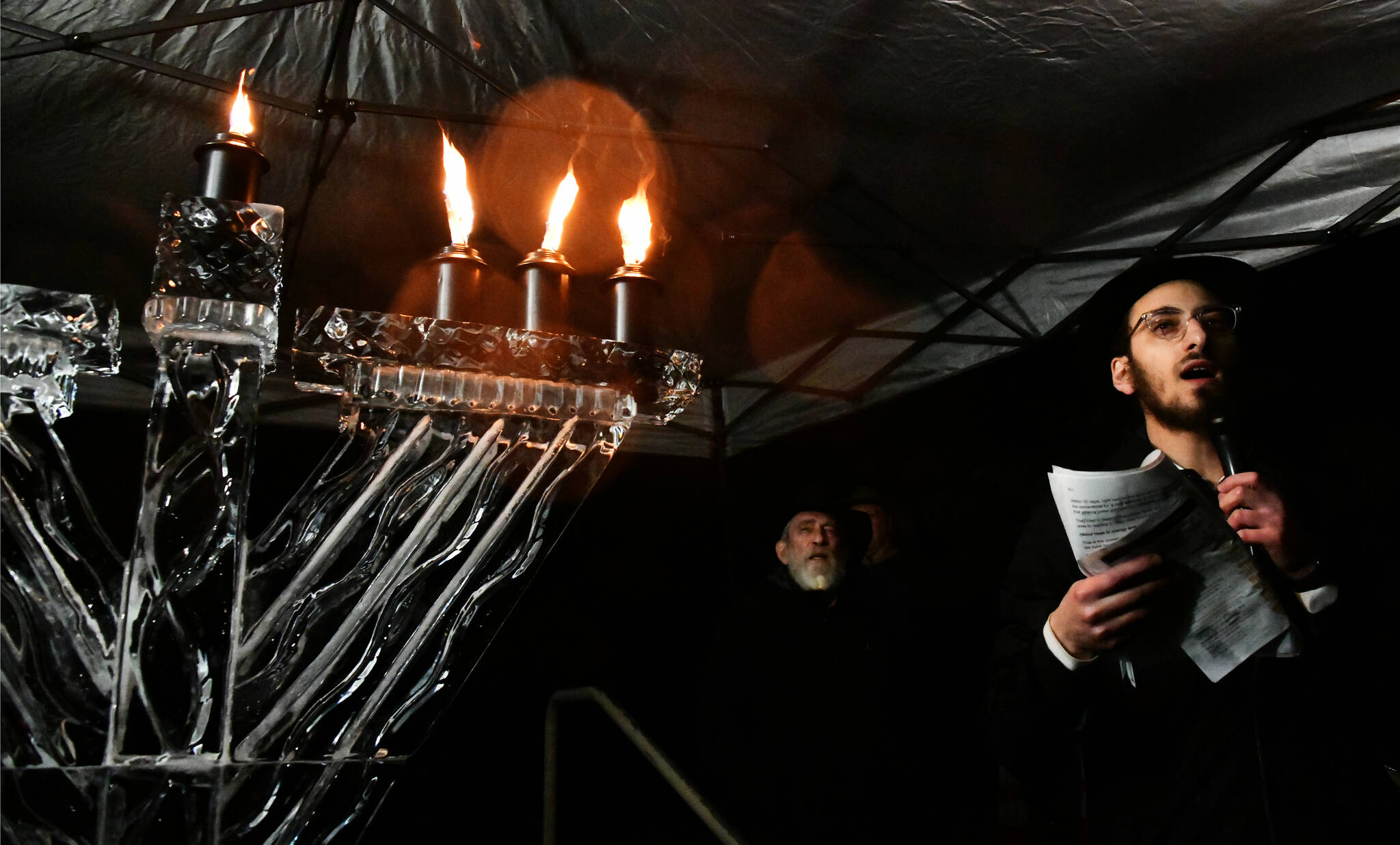 Rabbi Nissan Kornfeld of Chabad Mercer Island addresses the crowd after lighting the ice menorah on Dec. 16 at Mercerdale Park. Andy Nystrom/ staff photo