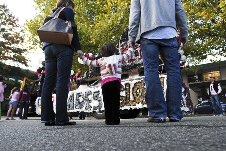 An Island family takes a closer look at the winning float entry by the MIHS Class of 2014 during the annual downtown homecoming parade on Friday evening. The freshman class brought home the first-place prize after a week’s worth of competition