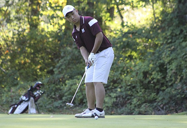 Brendan Yan putts on a par-3 hole during Mercer Island's golf meet against Interlake at Twin Rivers Golf Course. The Islanders beat the Saints