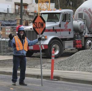 Synergy flagger Robert Flemming waves to drivers who pass in front of the Aviara construction project on 76th Ave. S.E.